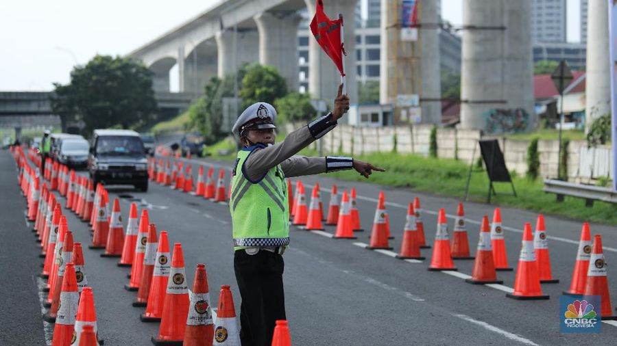 Petugas kepolisian berjaga di pos penyekatan arus balik lebaran di Tol Jakarta Cikampek KM 34B, Cikarang, Jawa Barat, Senin (17/5/2021). Direktorat Lalu Lintas (Ditlantas) Polda Metro Jaya serta sejumlah instansi terkait melakukan tes antigen secara gratis bagi pengendara yang belum memiliki surat bebas Covid-1 untuk kembali ke wilayah Jakarta dan Sekitarnya. Petugas gabungan terdiri dari TNI, Polri dan Satpol sebelumnya melakukan apel bersama, setidaknya ada 100 petugas gabungan yang ditugaskan dilokasi penyekatan. 
. (CNBC Indonesia/ Tri Susilo)