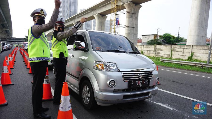 Petugas kepolisian berjaga di pos penyekatan arus balik lebaran di Tol Jakarta Cikampek KM 34B, Cikarang, Jawa Barat, Senin (17/5/2021). Direktorat Lalu Lintas (Ditlantas) Polda Metro Jaya serta sejumlah instansi terkait melakukan tes antigen secara gratis bagi pengendara yang belum memiliki surat bebas Covid-1 untuk kembali ke wilayah Jakarta dan Sekitarnya. Petugas gabungan terdiri dari TNI, Polri dan Satpol sebelumnya melakukan apel bersama, setidaknya ada 100 petugas gabungan yang ditugaskan dilokasi penyekatan. 
. (CNBC Indonesia/ Tri Susilo)