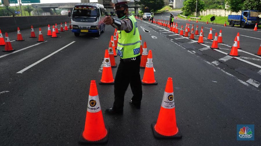 Petugas kepolisian berjaga di pos penyekatan arus balik lebaran di Tol Jakarta Cikampek KM 34B, Cikarang, Jawa Barat, Senin (17/5/2021). Direktorat Lalu Lintas (Ditlantas) Polda Metro Jaya serta sejumlah instansi terkait melakukan tes antigen secara gratis bagi pengendara yang belum memiliki surat bebas Covid-1 untuk kembali ke wilayah Jakarta dan Sekitarnya. Petugas gabungan terdiri dari TNI, Polri dan Satpol sebelumnya melakukan apel bersama, setidaknya ada 100 petugas gabungan yang ditugaskan dilokasi penyekatan. 
. (CNBC Indonesia/ Tri Susilo)