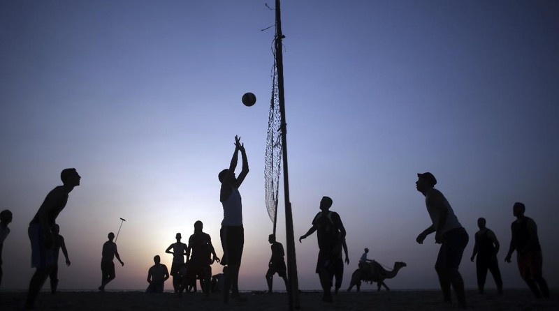 A Palestinians man plays with his child as the family enjoys a day at the beach of the Mediterranean sea in Gaza City, Friday, Sept. 18, 2020. (AP Photo/Hatem Moussa)