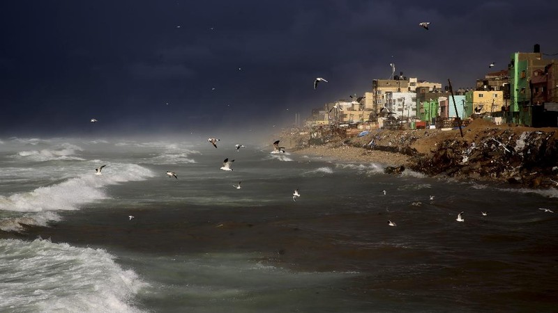 A Palestinians man plays with his child as the family enjoys a day at the beach of the Mediterranean sea in Gaza City, Friday, Sept. 18, 2020. (AP Photo/Hatem Moussa)