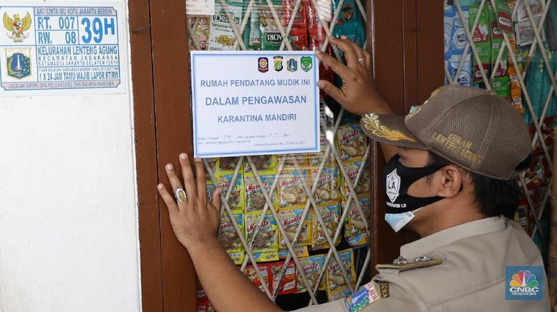 Gugus tugas Kelurahan Lenteng Agung memasangkan stiker tanda sedang menjalani isolasi mandir terhadap rumah pemudik yang baru balik ke Jakarta di kawasan Lenteng Agung, Jakarta, Senin, 17 Mei 2021. Pemerintah Kota Jakarta Selatan menginstruksikan setiap kelurahan untuk menempelkan stiker bertuliskan “pendatang mudik ini sedang menjalani isolasi mandiri 14 hari” di hunian pemudik yang baru datang dari kampung halaman. Hal itu dilakukan sebagai antisipasi arus balik pemudik dan menekan penyebaran Covid-19. 