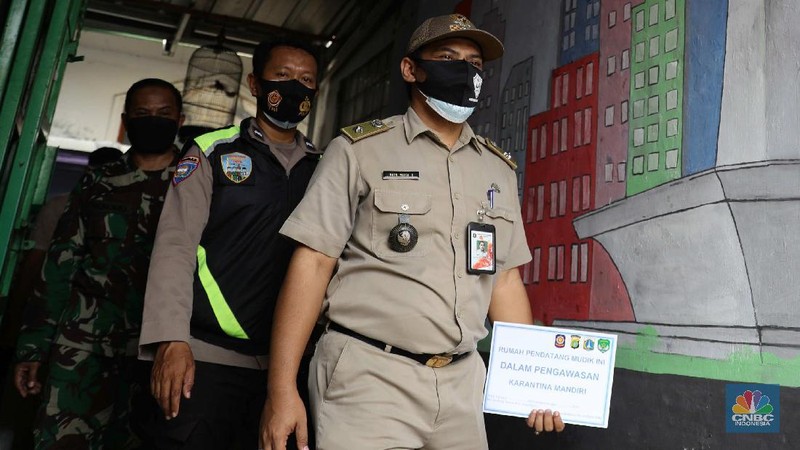 Gugus tugas Kelurahan Lenteng Agung memasangkan stiker tanda sedang menjalani isolasi mandir terhadap rumah pemudik yang baru balik ke Jakarta di kawasan Lenteng Agung, Jakarta, Senin, 17 Mei 2021. Pemerintah Kota Jakarta Selatan menginstruksikan setiap kelurahan untuk menempelkan stiker bertuliskan “pendatang mudik ini sedang menjalani isolasi mandiri 14 hari” di hunian pemudik yang baru datang dari kampung halaman. Hal itu dilakukan sebagai antisipasi arus balik pemudik dan menekan penyebaran Covid-19. 