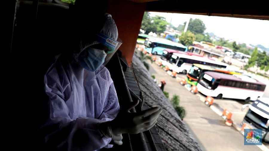 Petugas damkar menyemprot disinfektan kepada bus yang tiba dari daerah di terminal Kp Rambutan, Rabu, 19/5. Pasca berakhirnya peraturan larangan mudik Lebaran 2021, Terminal Kampung Rambutan kembali beroperasi melayani perjalanan ke luar kota dan ramai oleh penumpang tujuan Sumatra yang tidak kembali ke kampung halamannya pada Hari Raya Idul Fitri 1442 Hijriah lalu. Pantauan CNBC Indonesia pemudik dari luar Jabodetabek yang mulai berdatangan di terminal yang berlokasi di Kecamatan Ciracas, Jakarta Timur itu langsung disemprot disinfektan. Petugas juga melakukan tes rapid antigen secara acak bagi penumpang yang datang dari luar Jabodetabek. Pemandangan lain dilokasi keberangkatan juga ramai warga yang hendak pergi keluar kota. Terminal Kampung Rambutan menjadi salah satu terminal di Jakarta yang ditutup sementara selama periode larangan mudik Lebaran, 6-17 Mei 2021. Layanan bus antar kota antar provinsi (AKAP) tidak beroperasi selama periode tersebut.  (CNBC Indonesia/ Muhammad Sabki)