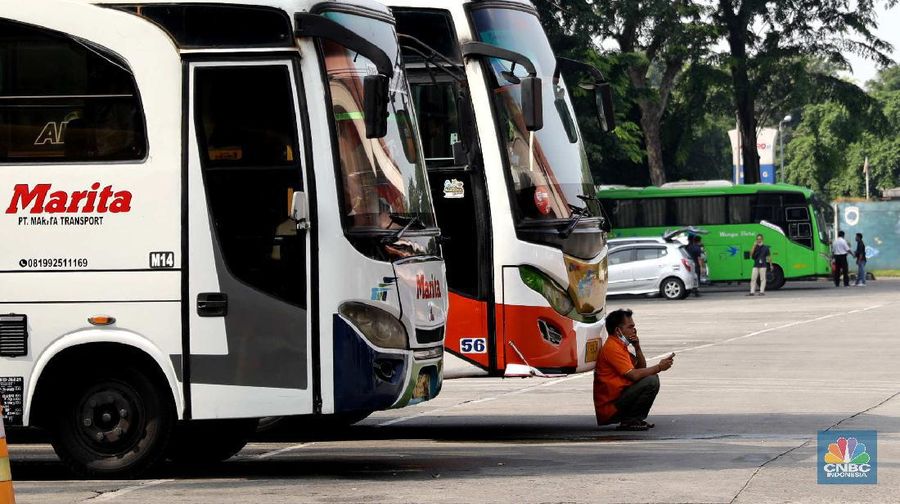Petugas damkar menyemprot disinfektan kepada bus yang tiba dari daerah di terminal Kp Rambutan, Rabu, 19/5. Pasca berakhirnya peraturan larangan mudik Lebaran 2021, Terminal Kampung Rambutan kembali beroperasi melayani perjalanan ke luar kota dan ramai oleh penumpang tujuan Sumatra yang tidak kembali ke kampung halamannya pada Hari Raya Idul Fitri 1442 Hijriah lalu. Pantauan CNBC Indonesia pemudik dari luar Jabodetabek yang mulai berdatangan di terminal yang berlokasi di Kecamatan Ciracas, Jakarta Timur itu langsung disemprot disinfektan. Petugas juga melakukan tes rapid antigen secara acak bagi penumpang yang datang dari luar Jabodetabek. Pemandangan lain dilokasi keberangkatan juga ramai warga yang hendak pergi keluar kota. Terminal Kampung Rambutan menjadi salah satu terminal di Jakarta yang ditutup sementara selama periode larangan mudik Lebaran, 6-17 Mei 2021. Layanan bus antar kota antar provinsi (AKAP) tidak beroperasi selama periode tersebut.  (CNBC Indonesia/ Muhammad Sabki)