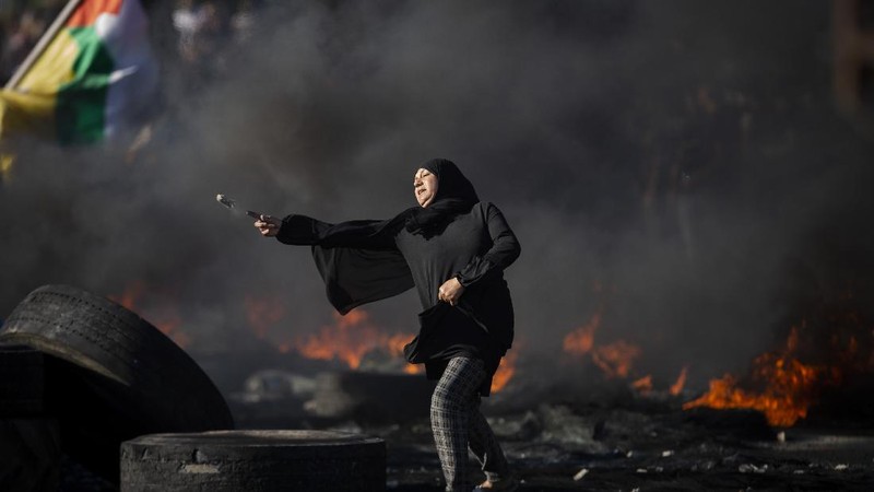 Palestinians clash with Israeli forces at the Hawara checkpoint, south of the West Bank city of Nablus, Tuesday, May 18, 2021. (AP Photo/Majdi Mohammed)
