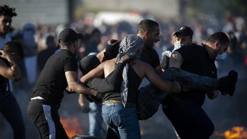 Palestinians clash with Israeli forces at the Hawara checkpoint, south of the West Bank city of Nablus, Tuesday, May 18, 2021. (AP Photo/Majdi Mohammed)