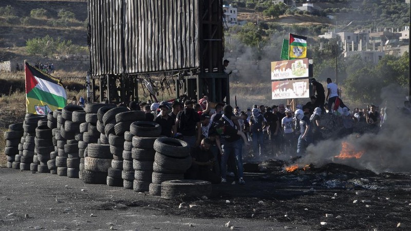 Palestinians clash with Israeli forces at the Hawara checkpoint, south of the West Bank city of Nablus, Tuesday, May 18, 2021. (AP Photo/Majdi Mohammed)