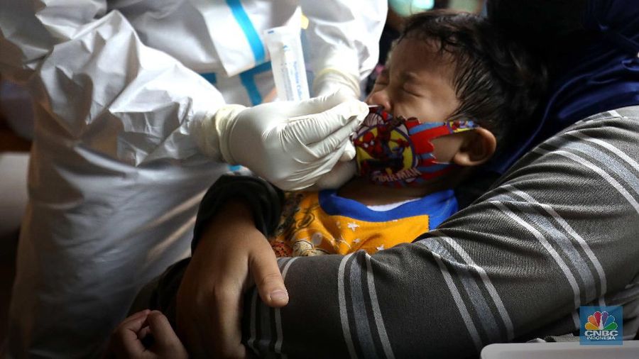 ‌Warga menjalani swab test PCR di kawasan RT 06/03 , Ciracas, Jakarta Timur, Kamis (20/Mei/2021). Sebanyak 24 warga atau delapan kepala keluarga (KK) di RT 06, RW 03, Kelurahan Ciracas, Jakarta Timur, terpapar Covid-19. Kawasan RT 03 langsung menerapkan lockdown atau Pengawasan Ketat Berskala Lokal (PKBL) di wilayah tersebut guna mencegah penyebaran Covid-19. Selama lockdown warga diwajibkan melaksanakan protokol kesehatan Covid-19 secara ketat dan dilarang keluar rumah apabila tidak ada keperluan mendesak. Pihaknya juga mengadakan swab test PCR massal warga setempat. Pihak kecamatan juga berkoordinasi dengan Dinas Sosial DKI Jakarta untuk memenuhi kebutuhan logistik warga RT tersebut. Delapan KK yang terpapar Covid-19 sebagian besar menjalani isolasi mandiri di Rumah Sakit Darurat Covid-19 Wisma Atlet Kemayoran. Pantauan CNBC Indonesia sejumlah warga terpaksa beraktifitas dari rumah. Okie yang keseharian nya menjadi badut di sekitar Ciracas terpaksa harus menahan diri dari rumah karena ada himbauan untuk tetap dirumah. 