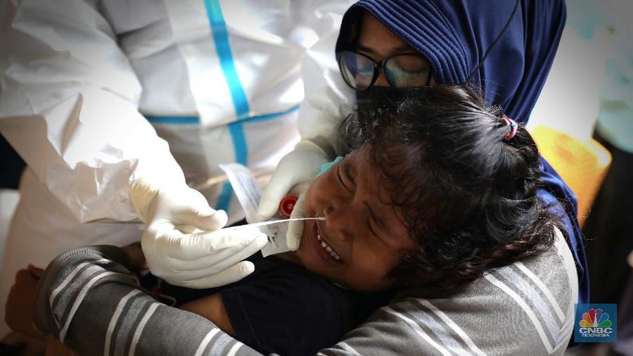 Warga menjalani swab test PCR di kawasan RT 06/03 , Ciracas, Jakarta Timur, Kamis (20/Mei/2021). Sebanyak 24 warga atau delapan kepala keluarga (KK) di RT 06, RW 03, Kelurahan Ciracas, Jakarta Timur, terpapar Covid-19. Kawasan RT 03 langsung menerapkan lockdown atau Pengawasan Ketat Berskala Lokal (PKBL) di wilayah tersebut guna mencegah penyebaran Covid-19. Selama lockdown warga diwajibkan melaksanakan protokol kesehatan Covid-19 secara ketat dan dilarang keluar rumah apabila tidak ada keperluan mendesak. Pihaknya juga mengadakan swab test PCR massal warga setempat. Pihak kecamatan juga berkoordinasi dengan Dinas Sosial DKI Jakarta untuk memenuhi kebutuhan logistik warga RT tersebut. Delapan KK yang terpapar Covid-19 sebagian besar menjalani isolasi mandiri di Rumah Sakit Darurat Covid-19 Wisma Atlet Kemayoran. Pantauan CNBC Indonesia sejumlah warga terpaksa beraktifitas dari rumah. Okie yang keseharian nya menjadi badut di sekitar Ciracas terpaksa harus menahan diri dari rumah karena ada himbauan untuk tetap dirumah.