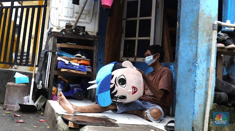 ‌Warga menjalani swab test PCR di kawasan RT 06/03 , Ciracas, Jakarta Timur, Kamis (20/Mei/2021). Sebanyak 24 warga atau delapan kepala keluarga (KK) di RT 06, RW 03, Kelurahan Ciracas, Jakarta Timur, terpapar Covid-19. Kawasan RT 03 langsung menerapkan lockdown atau Pengawasan Ketat Berskala Lokal (PKBL) di wilayah tersebut guna mencegah penyebaran Covid-19. Selama lockdown warga diwajibkan melaksanakan protokol kesehatan Covid-19 secara ketat dan dilarang keluar rumah apabila tidak ada keperluan mendesak. Pihaknya juga mengadakan swab test PCR massal warga setempat. Pihak kecamatan juga berkoordinasi dengan Dinas Sosial DKI Jakarta untuk memenuhi kebutuhan logistik warga RT tersebut. Delapan KK yang terpapar Covid-19 sebagian besar menjalani isolasi mandiri di Rumah Sakit Darurat Covid-19 Wisma Atlet Kemayoran. Pantauan CNBC Indonesia sejumlah warga terpaksa beraktifitas dari rumah. Okie yang keseharian nya menjadi badut di sekitar Ciracas terpaksa harus menahan diri dari rumah karena ada himbauan untuk tetap dirumah. 