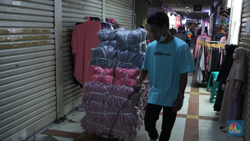 Pengunjung mencoba busana pakaian di Pasar Tanah Abang Blok B, Jakarta, Kamis (20/5/2021). Pasar Tanah Abang Blok A dan B kembali buka namun tidak banyak pengunjung usai tutup sementara pada 12-18 Mei 2021 lalu. Pantauan CNBC Indonesia masih banyak toko yang tutup di Blok A dan B dan aktifitas pengunjung juga tidak dibatasi oleh pihak pengelola.  (CNBC Indonesia/ Tri Susilo)