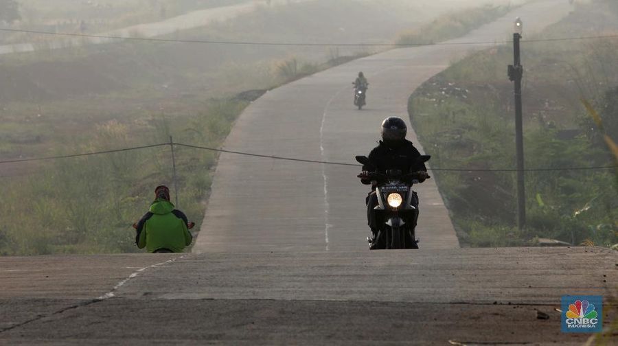 Sejumlah pengendara motor melintas jalan Bojonggede - Kemang dari ruas Kemang, Bogor, Jawa Barat, Kamis (20/5/2021). Jalan Bojonggede-Kemang di Bogor sudah bisa dilewati secara fungsional walau proyek belum 100 persen rampung. Meski sudah banyak di lewati namun Marka jalan di sepanjang jalan tersebut belum dipasang. Lampu dan penerangan jalan juga belum terpasang. Sejauh ini jalan sudah di beton halus sepanjang 5 Km dari wilayah Kemang sampai Nanggerang, tajur Halang. Jalan Bojonggede - Kemang ini akan didorong menjadi jalan nasional. Jalan ini akan menghubungkan jalan raya nasional, jalan raya Bogor dan jalan raya Parung.  (CNBC Indonesia/ Muhammad Sabki)