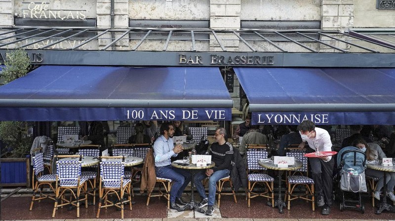 Customers drink beers at cafe terraces in Paris, Wednesday, May, 19, 2021. It's a grand day for the French. Cafe and restaurant terraces reopened Wednesday after a six-month coronavirus shutdown deprived residents of the essence of French 