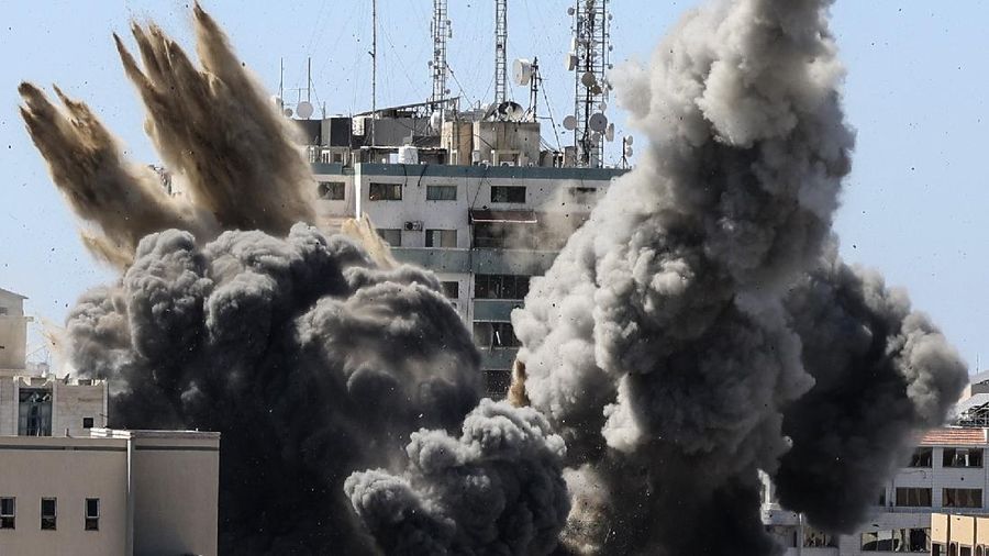 Asap mengepul dari gedung yang menampung berbagai media internasional, termasuk The Associated Press, setelah serangan udara Israel pada hari Sabtu, 15 Mei 2021 di Kota Gaza. Serangan itu terjadi kira-kira satu jam setelah militer Israel memerintahkan orang-orang untuk mengungsi dari gedung, yang juga menampung Al-Jazeera dan sejumlah kantor dan apartemen. Tidak ada penjelasan langsung mengapa bangunan itu menjadi sasaran. (Mahmud Hams /Pool Photo via AP)