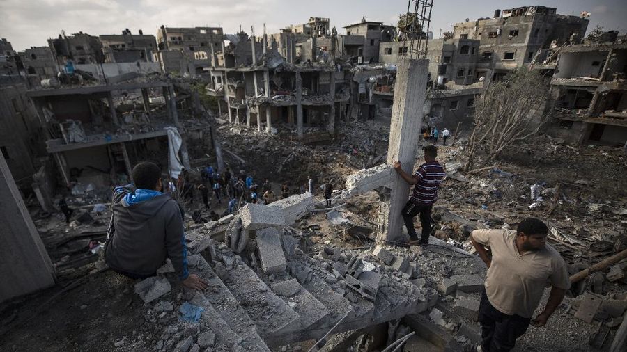 Warga Palestina memeriksa rumah mereka yang hancur setelah serangan udara Israel semalam di kota Beit Hanoun, Jalur Gaza utara, Jumat, 14 Mei 2021. (AP / Khalil Hamra)