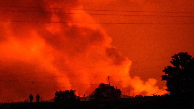 Two people are seen silhouetted against a night sky turned red by the eruption of Mount Nyiragongo, in Goma, Congo Saturday, May 22, 2021. Congo's Mount Nyiragongo erupted for the first time in nearly two decades Saturday, turning the night sky a fiery red and sending lava onto a major highway as panicked residents tried to flee Goma, a city of nearly 2 million. (AP Photo/Justin Kabumba)