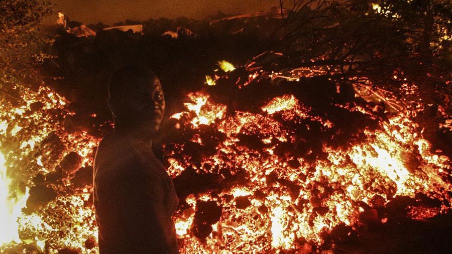 Two people are seen silhouetted against a night sky turned red by the eruption of Mount Nyiragongo, in Goma, Congo Saturday, May 22, 2021. Congo's Mount Nyiragongo erupted for the first time in nearly two decades Saturday, turning the night sky a fiery red and sending lava onto a major highway as panicked residents tried to flee Goma, a city of nearly 2 million. (AP Photo/Justin Kabumba)