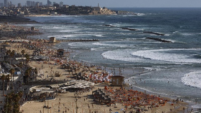 People enjoy the beach front in Tel Aviv, Israel, Saturday, May 22, 2021. A cease-fire took effect early Friday after 11 days of heavy fighting between Israel and Gaza's militant Hamas rulers that was ignited by protests and clashes in Jerusalem. (AP Photo/Oded Balilty)