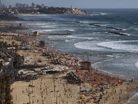 People enjoy the beach front in Tel Aviv, Israel, Saturday, May 22, 2021. A cease-fire took effect early Friday after 11 days of heavy fighting between Israel and Gaza's militant Hamas rulers that was ignited by protests and clashes in Jerusalem. (AP