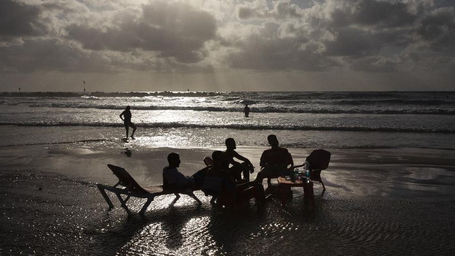 People enjoy the beachfront in Tel Aviv, Israel, Saturday, May 22, 2021. A cease-fire took effect early Friday after 11 days of heavy fighting between Israel and Gaza's militant Hamas rulers that was ignited by protests and clashes in Jerusalem. (AP Photo/Oded Balilty)