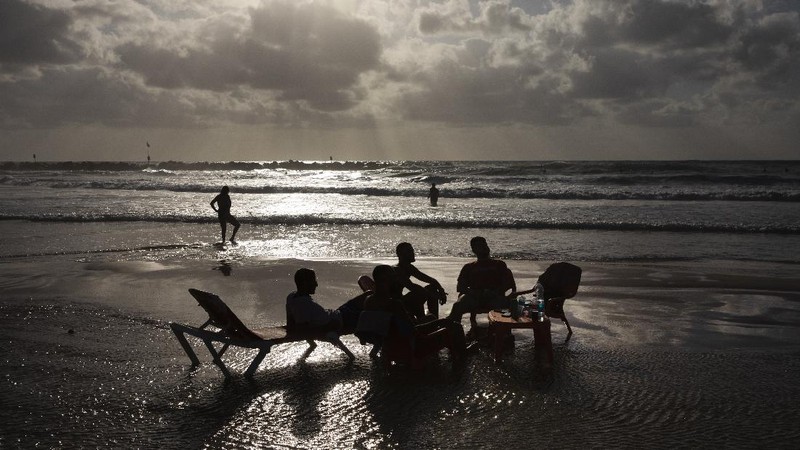 People enjoy the beach front in Tel Aviv, Israel, Saturday, May 22, 2021. A cease-fire took effect early Friday after 11 days of heavy fighting between Israel and Gaza's militant Hamas rulers that was ignited by protests and clashes in Jerusalem. (AP Photo/Oded Balilty)