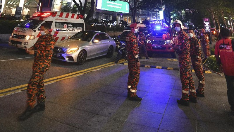 Petugas membantu penumpang yang terluka dalam insiden tabrakan dua kereta LRT di Malaysia. AP/