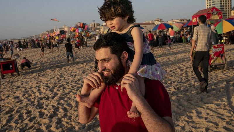 Setelah gencatan senjata, warga Palestina berlibur ke pantai  Mediterania. (AP/John Minchillo)