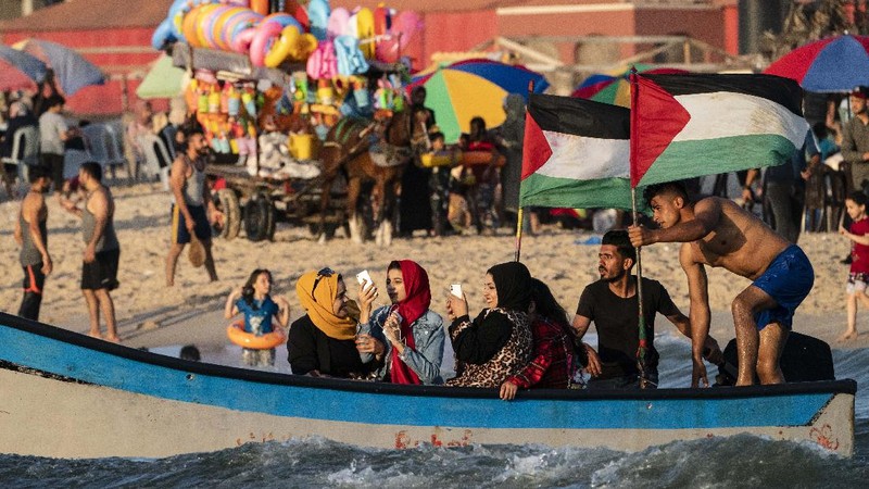 Setelah gencatan senjata, warga Palestina berlibur ke pantai  Mediterania. (AP/John Minchillo)