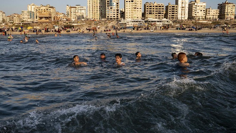 Setelah gencatan senjata, warga Palestina berlibur ke pantai  Mediterania. (AP/John Minchillo)