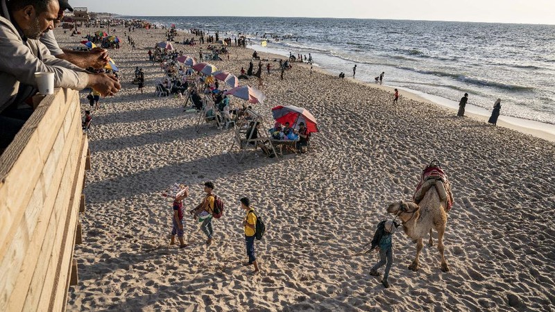 Setelah gencatan senjata, warga Palestina berlibur ke pantai  Mediterania. (AP/John Minchillo)