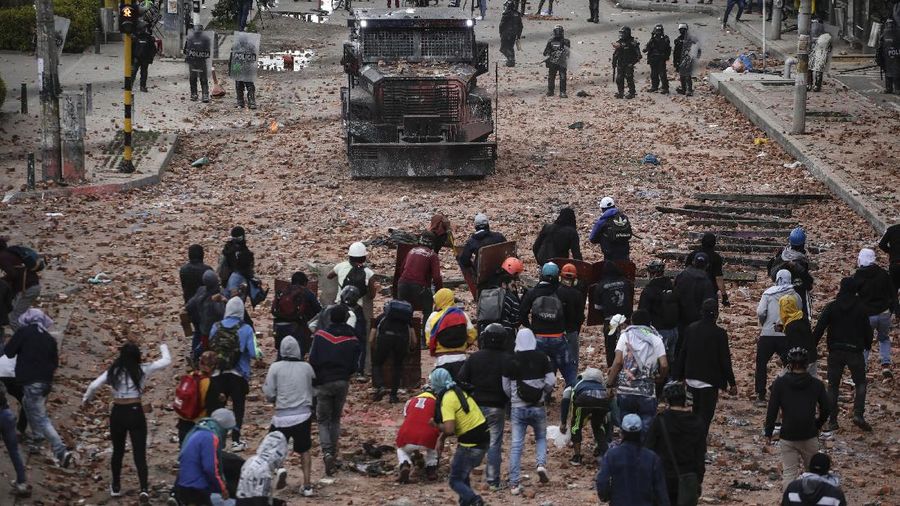 Protesters who call themselves the front line hold homemade shields during an anti-government protest in Bogota, Colombia, Friday, May 28, 2021. Colombians have taken to the streets for weeks across the country after the government proposed tax increases on public services, fuel, wages and pensions. (AP Photo/Fernando Vergara)