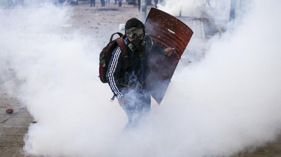 Protesters who call themselves the front line hold homemade shields during an anti-government protest in Bogota, Colombia, Friday, May 28, 2021. Colombians have taken to the streets for weeks across the country after the government proposed tax increases on public services, fuel, wages and pensions. (AP Photo/Fernando Vergara)