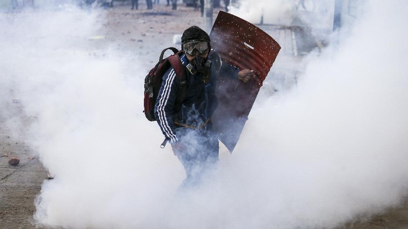 Protesters who call themselves the front line hold homemade shields during an anti-government protest in Bogota, Colombia, Friday, May 28, 2021. Colombians have taken to the streets for weeks across the country after the government proposed tax increases on public services, fuel, wages and pensions. (AP Photo/Fernando Vergara)