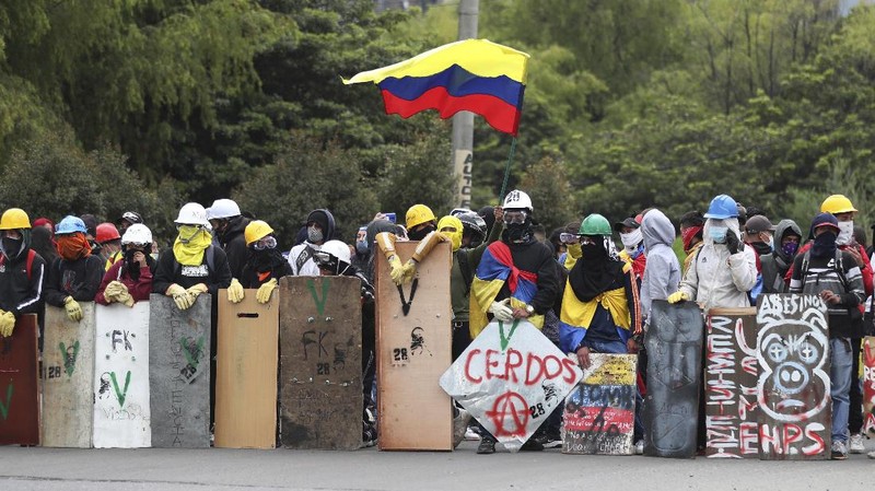 Protesters who call themselves the front line hold homemade shields during an anti-government protest in Bogota, Colombia, Friday, May 28, 2021. Colombians have taken to the streets for weeks across the country after the government proposed tax increases on public services, fuel, wages and pensions. (AP Photo/Fernando Vergara)