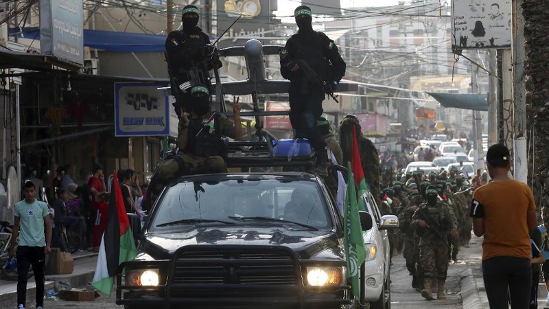Masked militants from the Izzedine al-Qassam Brigades, a military wing of Hamas, march with their rifles a long the streets of Nusseirat refugee camp, central Gaza Strip, Friday, May 28, 2021. Arabic on the headband reads 