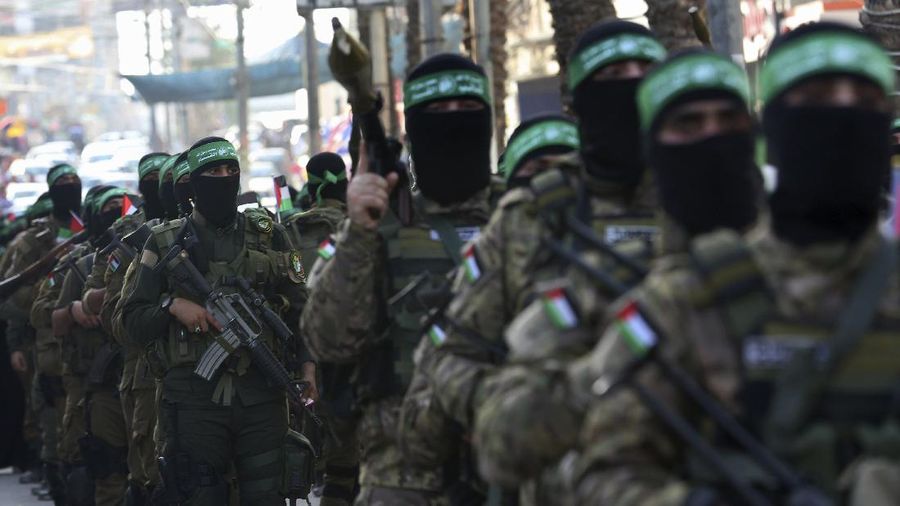 Masked militants from the Izzedine al-Qassam Brigades, a military wing of Hamas, march with their rifles a long the streets of Nusseirat refugee camp, central Gaza Strip, Friday, May 28, 2021. Arabic on the headband reads 