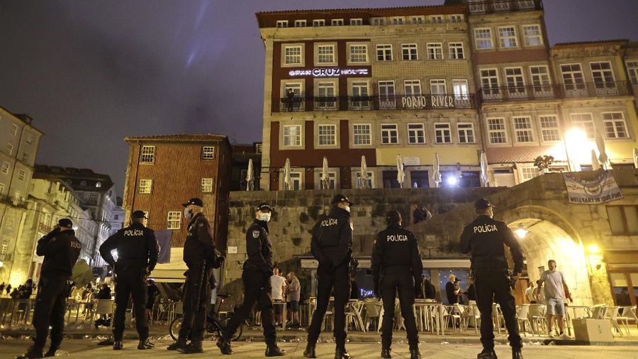 Police moves in to stop a scuffle that started among Manchester City supporters drinking by the Douro river bank in Porto, Portugal, Friday, May 28, 2021. English clubs Manchester City and Chelsea will play the Champions League soccer final in Porto on Saturday. (AP Photo/Luis Vieira)