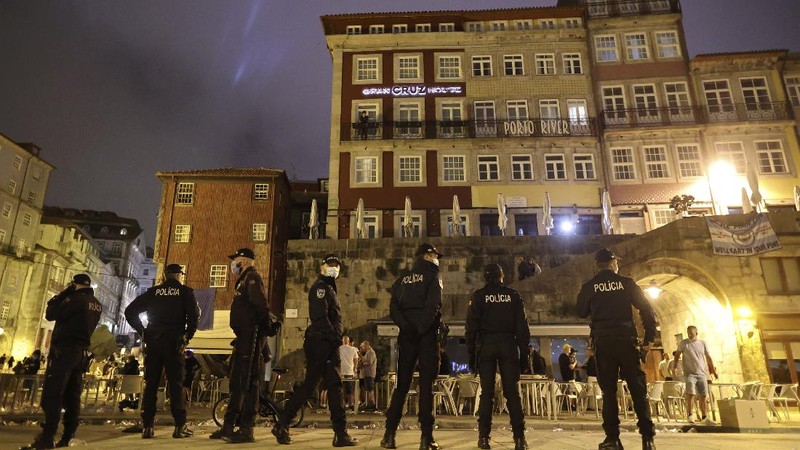 Police moves in to stop a scuffle that started among Manchester City supporters drinking by the Douro river bank in Porto, Portugal, Friday, May 28, 2021. English clubs Manchester City and Chelsea will play the Champions League soccer final in Porto on Saturday. (AP Photo/Luis Vieira)