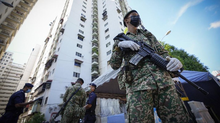 Virus Outbreak Malaysia Armed soldiers stand guard outside Pangsapuri Permai, residential area placed under the enhanced movement control order (EMCO) due to drastic increase in the number of COVID-19 cases recorded over the past 10 days in Cheras, outskirt of Kuala Lumpur, Malaysia, Friday, May 28, 2021. Malaysia's latest coronavirus surge has been taking a turn for the worse as surging numbers and deaths have caused alarm among health officials, while cemeteries in the capital are dealing with an increasing number of deaths. (AP Photo/Vincent Thian)