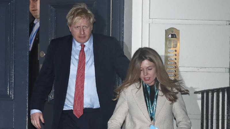 Britain's Prime Minister Boris Johnson and his partner Carrie Symonds, stand outside 10 Downing Street to join in the nationwide Clap for Carers to recognise and support National Health Service (NHS) workers and carers fighting the coronavirus pandemic, in London Thursday May 14, 2020. The highly contagious COVID-19 coronavirus has impacted on nations around the globe, many imposing self isolation and exercising social distancing when people move from their homes. (Victoria Jones / PA via AP)