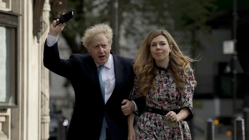 Britain's Prime Minister Boris Johnson and his partner Carrie Symonds, stand outside 10 Downing Street to join in the nationwide Clap for Carers to recognise and support National Health Service (NHS) workers and carers fighting the coronavirus pandemic, in London Thursday May 14, 2020. The highly contagious COVID-19 coronavirus has impacted on nations around the globe, many imposing self isolation and exercising social distancing when people move from their homes. (Victoria Jones / PA via AP)