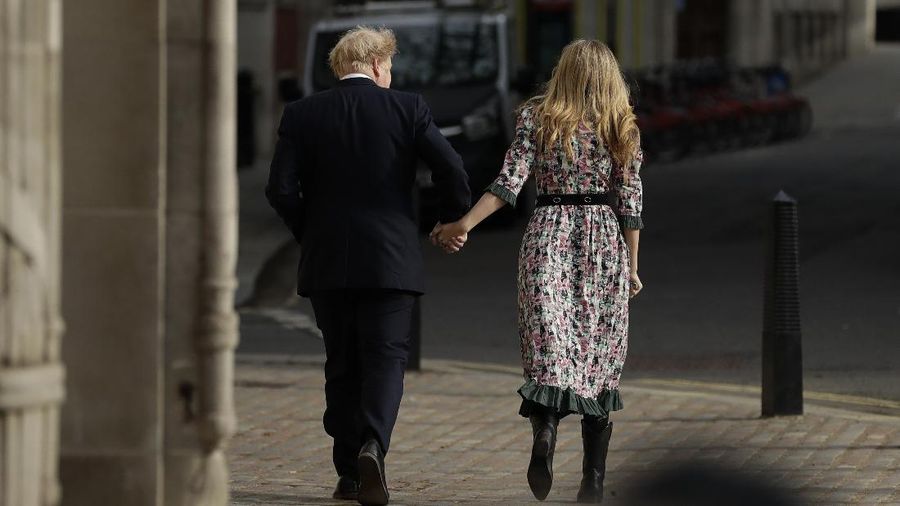 Britain's Prime Minister Boris Johnson and his partner Carrie Symonds, stand outside 10 Downing Street to join in the nationwide Clap for Carers to recognise and support National Health Service (NHS) workers and carers fighting the coronavirus pandemic, in London Thursday May 14, 2020. The highly contagious COVID-19 coronavirus has impacted on nations around the globe, many imposing self isolation and exercising social distancing when people move from their homes. (Victoria Jones / PA via AP)