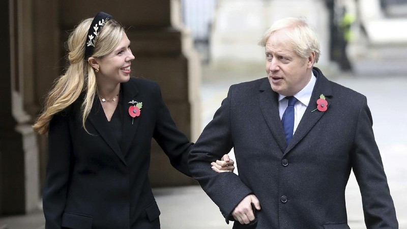 Britain's Prime Minister Boris Johnson and his partner Carrie Symonds, stand outside 10 Downing Street to join in the nationwide Clap for Carers to recognise and support National Health Service (NHS) workers and carers fighting the coronavirus pandemic, in London Thursday May 14, 2020. The highly contagious COVID-19 coronavirus has impacted on nations around the globe, many imposing self isolation and exercising social distancing when people move from their homes. (Victoria Jones / PA via AP)