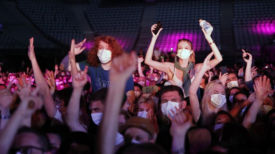 Thousands of people, masked and tested for the virus, pack inside a Paris concert hall as part of a public health experiment to prepare the country to host big events again, in Paris, Saturday, May 29, 2021. The concert in the AccorHotels Arena in eastern Paris features 1980s French rock band Indochine and DJ Etienne de Crecy. (AP Photo/Francois Mori)
