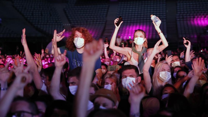 Thousands of people, masked and tested for the virus, pack inside a Paris concert hall as part of a public health experiment to prepare the country to host big events again, in Paris, Saturday, May 29, 2021. The concert in the AccorHotels Arena in eastern Paris features 1980s French rock band Indochine and DJ Etienne de Crecy. (AP Photo/Francois Mori)