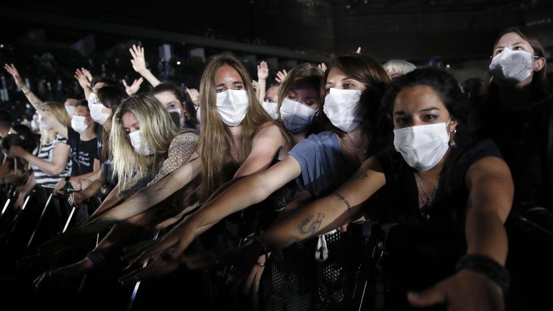 Thousands of people, masked and tested for the virus, pack inside a Paris concert hall as part of a public health experiment to prepare the country to host big events again, in Paris, Saturday, May 29, 2021. The concert in the AccorHotels Arena in eastern Paris features 1980s French rock band Indochine and DJ Etienne de Crecy. (AP Photo/Francois Mori)