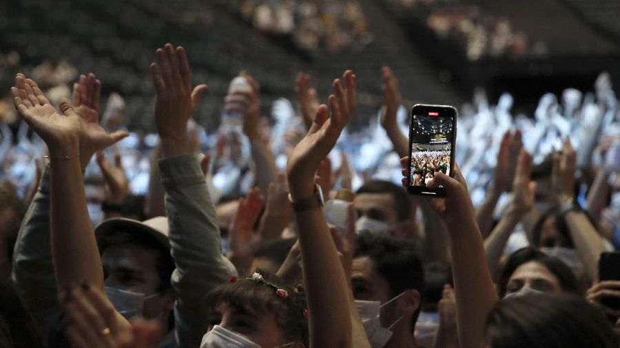 Thousands of people, masked and tested for the virus, pack inside a Paris concert hall as part of a public health experiment to prepare the country to host big events again, in Paris, Saturday, May 29, 2021. The concert in the AccorHotels Arena in eastern Paris features 1980s French rock band Indochine and DJ Etienne de Crecy. (AP Photo/Francois Mori)