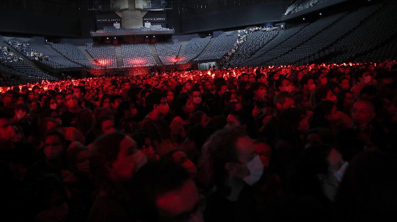 Thousands of people, masked and tested for the virus, pack inside a Paris concert hall as part of a public health experiment to prepare the country to host big events again, in Paris, Saturday, May 29, 2021. The concert in the AccorHotels Arena in eastern Paris features 1980s French rock band Indochine and DJ Etienne de Crecy. (AP Photo/Francois Mori)