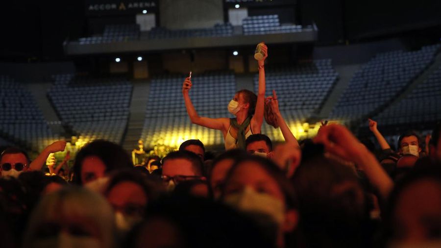 Thousands of people, masked and tested for the virus, pack inside a Paris concert hall as part of a public health experiment to prepare the country to host big events again, in Paris, Saturday, May 29, 2021. The concert in the AccorHotels Arena in eastern Paris features 1980s French rock band Indochine and DJ Etienne de Crecy. (AP Photo/Francois Mori)